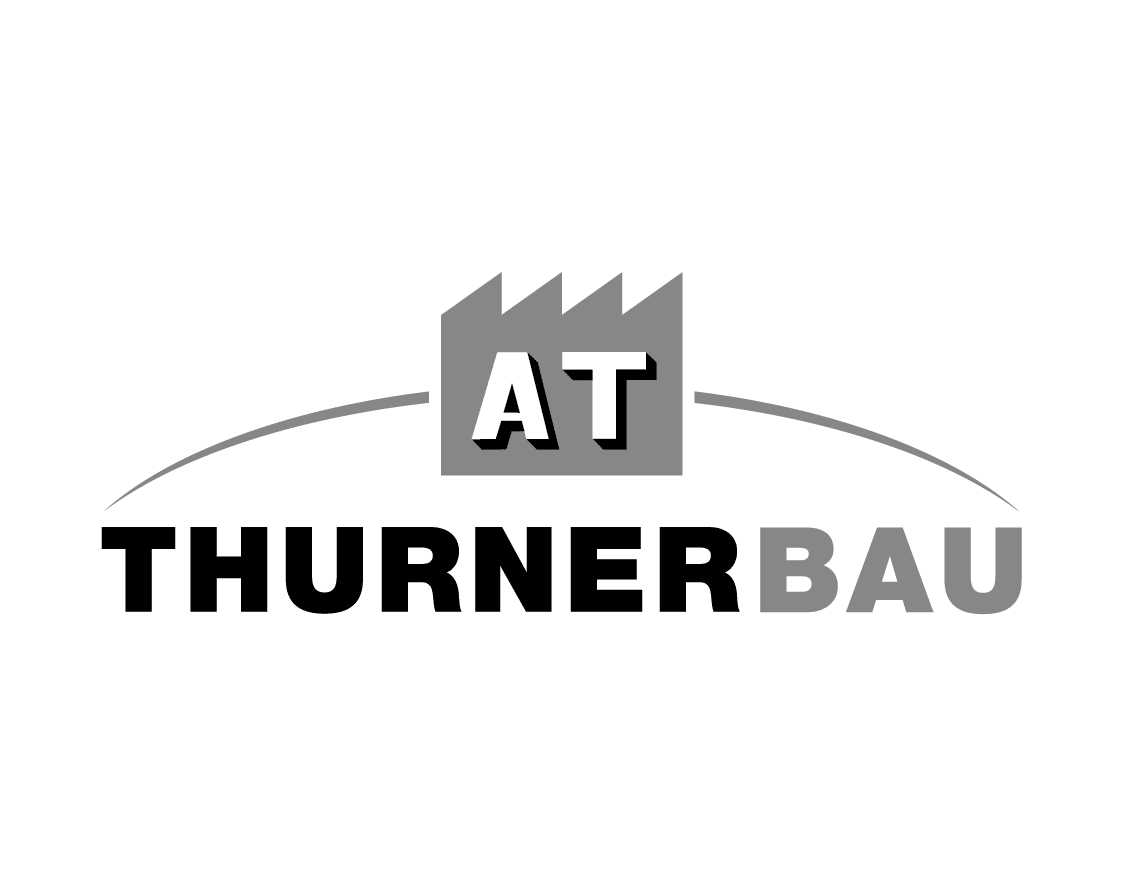 Logo mit einem Fabriksymbol über dem Text AT THURNERBAU in fetten, schwarzen und grauen Buchstaben.
